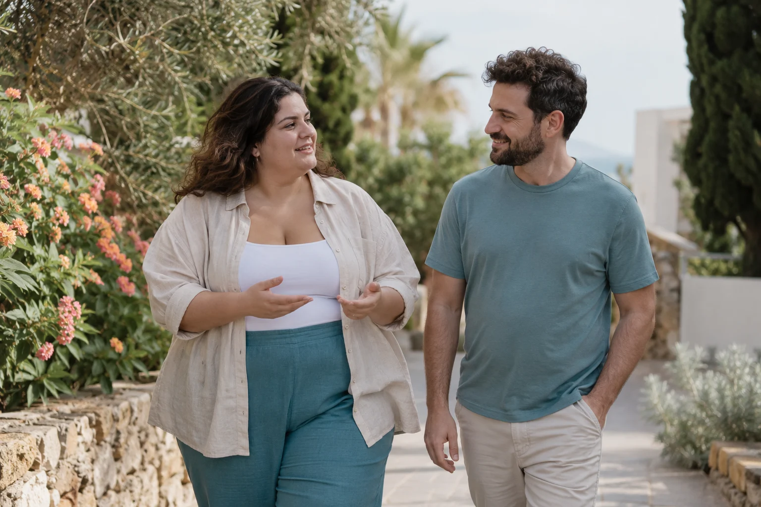 Dos personas adultas conversan mientras pasean por un jardín